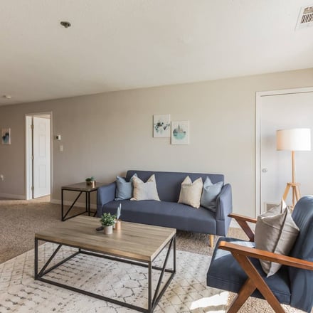 Spacious living room with blue sofa and natural light